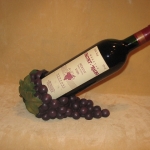 uvas sujeta botella de vino